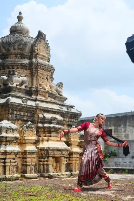 A pose before the towering temple gopuram