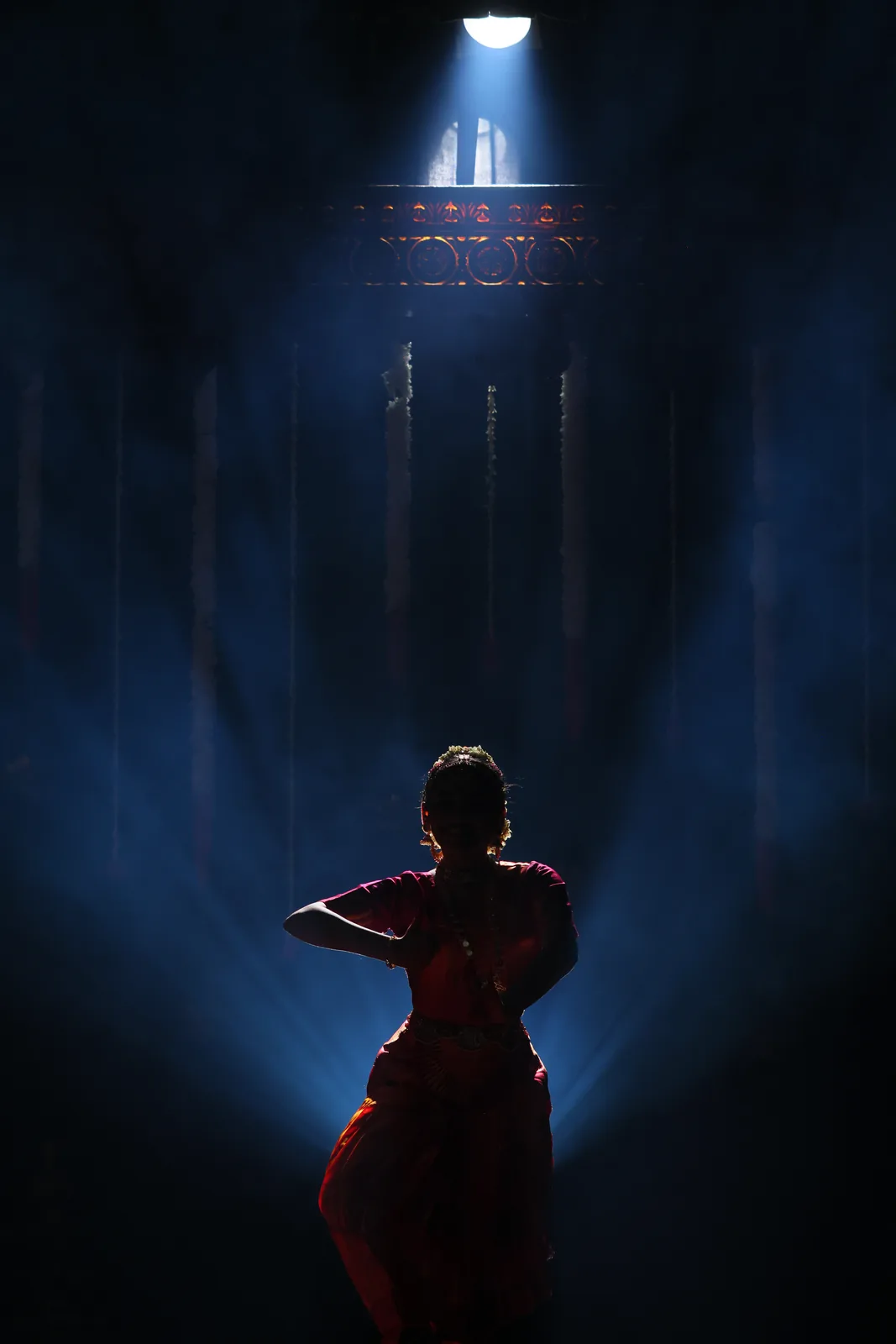 Ananya facing the stage lights before the Nataraja emblem