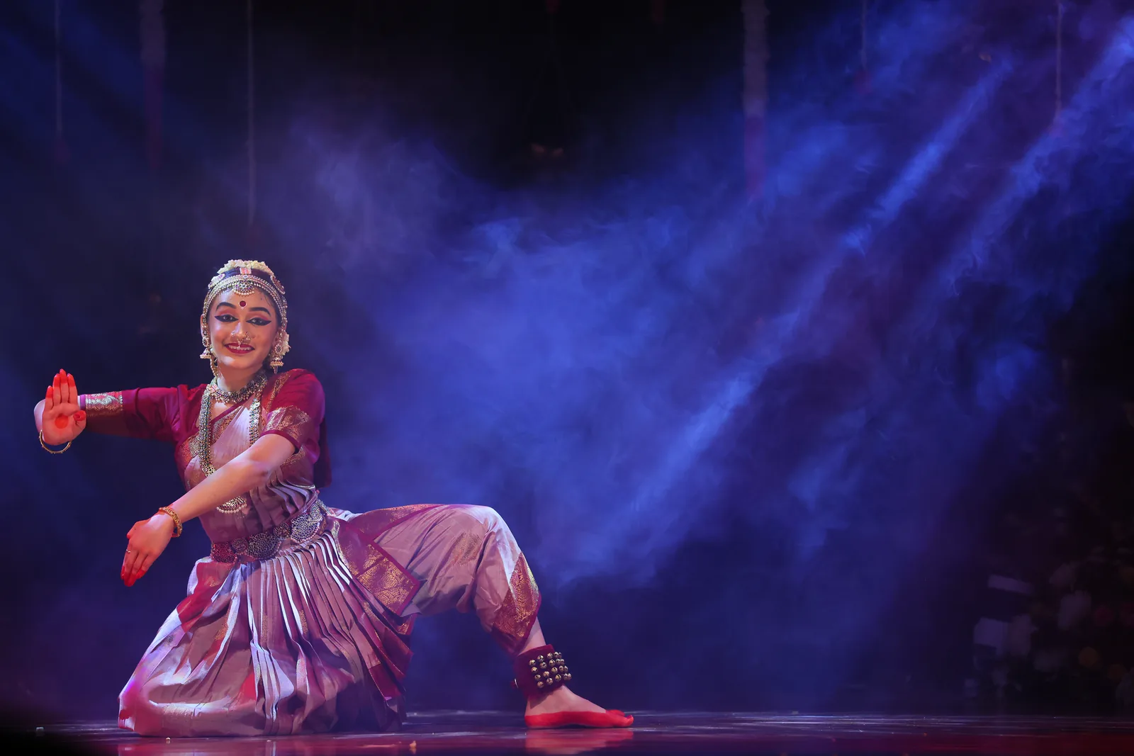 A crouched pose amid dramatic stage smoke