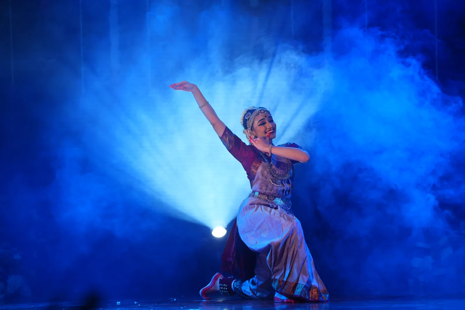 A kneeling pose lit by dramatic stage lighting