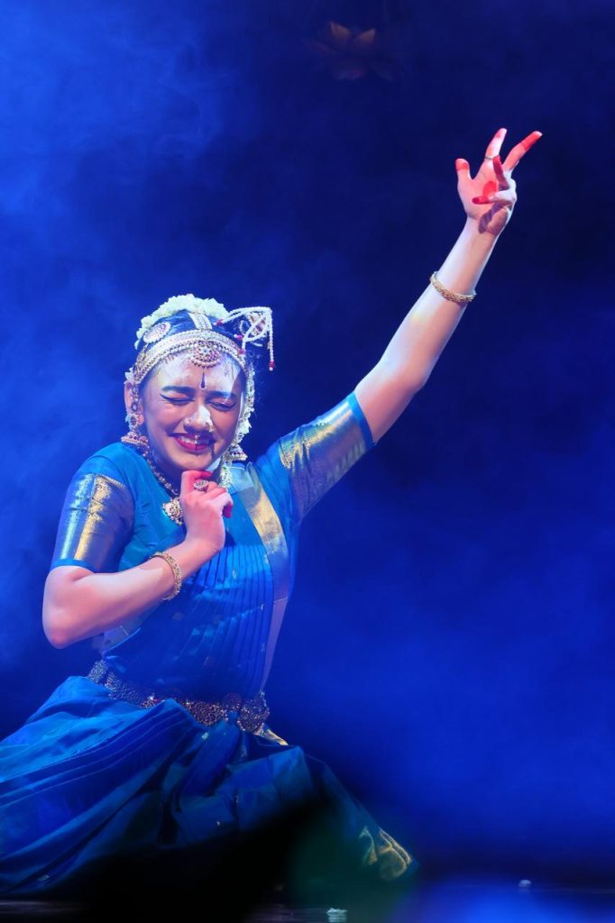 Ananya performing an expressive sequence under blue stage lighting